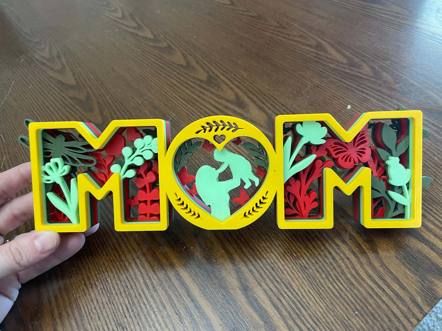 Layered MOM decoration in yellow, red, and green