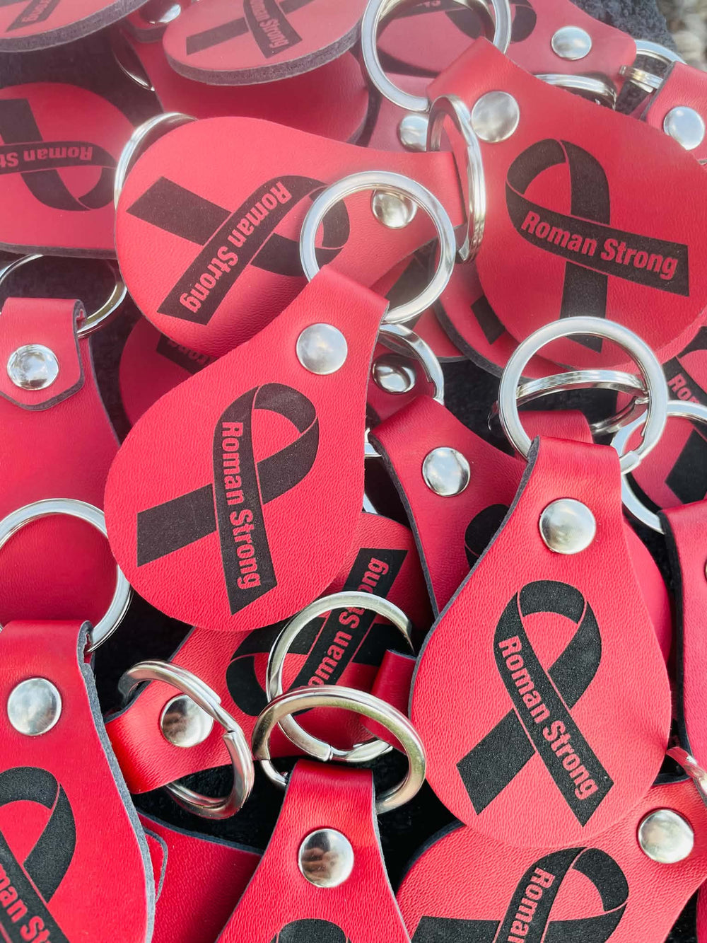 Personalized red keychains engraved with the Roman Strong ribbon design